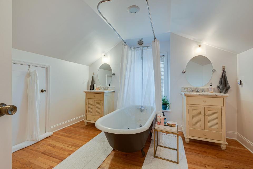 The primary bath features a freestanding clawfoot tub and shower with dual vanities plus ample shelf space.