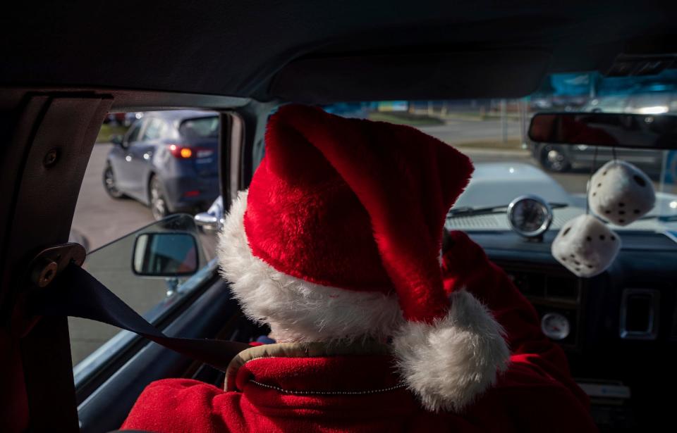 A Secret Santa elf drives a vehicle looking for people to hand them $100 bills during the annual Secret Santa in Lincoln Park event on Thursday, Dec. 14, 2023.