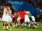 Germany's Thomas Mueller (L) and teammate Bastian Schweinsteiger embrace as they celebrate their win against Argentina during their 2014 World Cup final at the Maracana stadium in Rio de Janeiro July 13, 2014. REUTERS/Michael Dalder