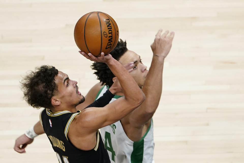 Atlanta Hawks guard Trae Young (11) drives to the basket as Boston Celtics guard Carsen Edwards (4) defends In the first half of an NBA basketball game Wednesday, Feb. 24, 2021, in Atlanta. (AP Photo/John Bazemore)