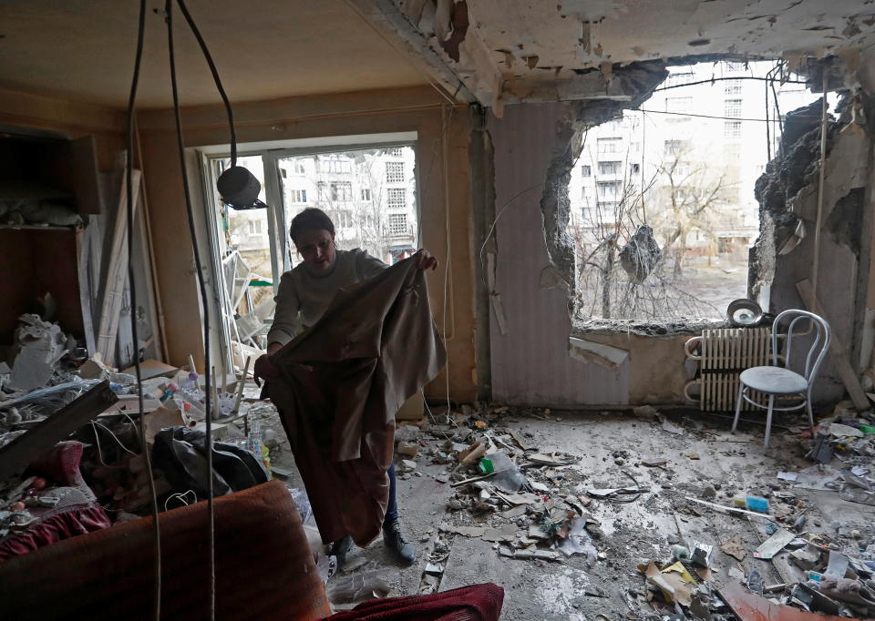 A woman inspects debris inside an apartment of a residential building, which locals said was damaged by recent shelling, in the separatist-controlled town of Horlivka (Gorlovka) in the Donetsk region, Ukraine March 2, 2022. REUTERS/Alexander Ermochenko