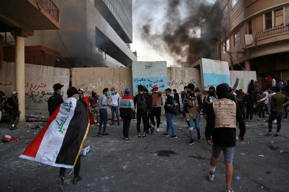 Protesters gather during clashes between Iraqi security forces and anti-Government protesters in Baghdad, Iraq, Thursday, Nov. 21, 2019. Iraqi officials said several protesters were killed as heavy clashes erupt in central Baghdad. (AP Photo/Khalid Mohammed)