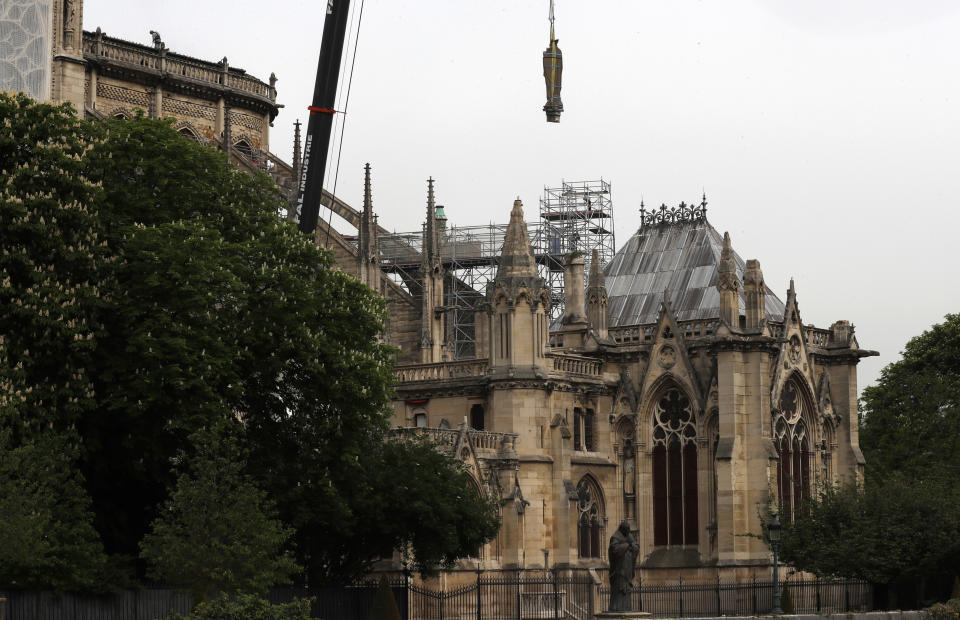 A statue is removed from Notre Dame cathedral,Tuesday, April 23, 2019 in Paris. The man in charge of the restoration of the fire-ravaged Notre Dame cathedral says he has appointed professional mountain climbers to install temporary tarps over the building to offset potential rain damage. (AP Photo/Thibault Camus)