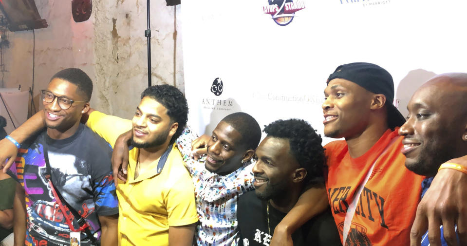 Oklahoma City Thunder guard Russell Westbrook, second from right, poses with friends and business associates at his Why Not? Foundation’s Comedy Show in Tulsa, Okla., on Thursday night, July 11, 2019. Westbrook showed up less than an hour after the news broke that he was to be traded to the Houston Rockets. (AP Photo/Cliff Brunt)