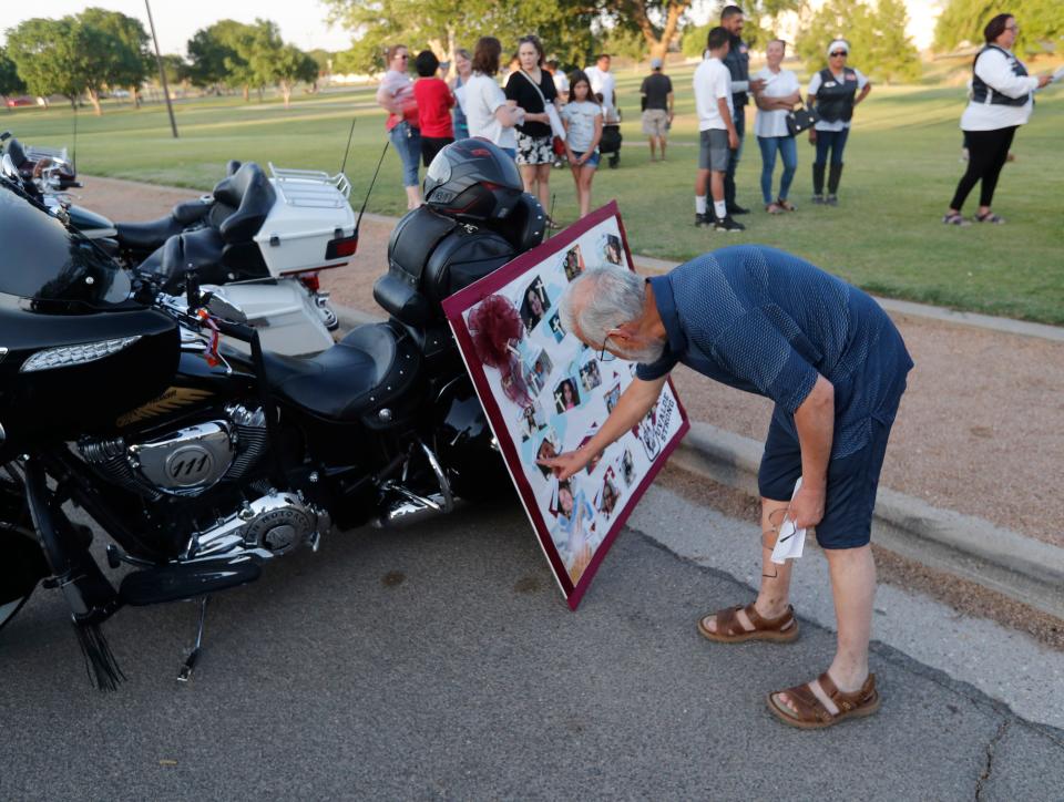 Francisco Luebano looks at a poster showing the students and teachers killed in Uvalde. People visited Charles A. Guy Park to pay their respects for the students and teachers killed Friday, May 27, 2021. (Mark Rogers/For A-J Media)