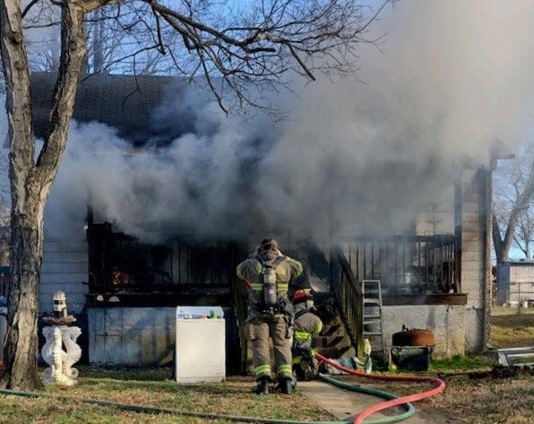 Two Lexington firefighters sustained minor injuries while responding to a housefire on West Seventh Street Extension on Monday.