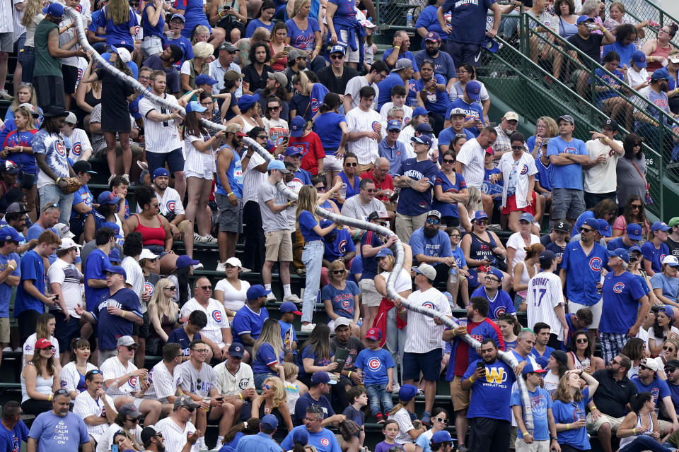 Fans make a beer cup snake during the fifth inning of a baseball game between the Miami Marlins and the Chicago Cubs in Chicago, Sunday, June 20, 2021. (AP Photo/Nam Y. Huh)