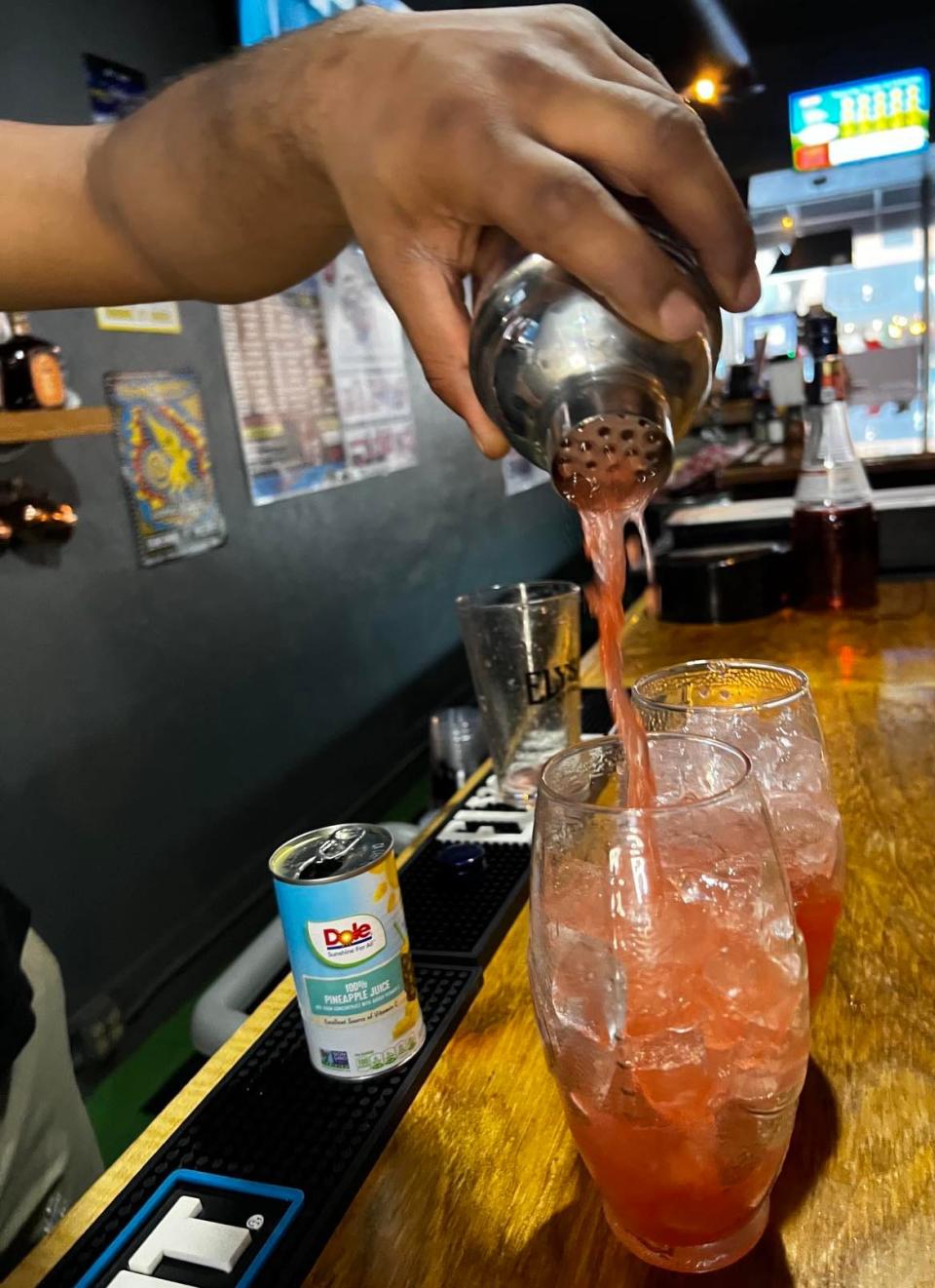 Jamal Gomez, of Gridiron Pizza & Sports Bar in downtown Canton, pours one of his specialty cocktails.