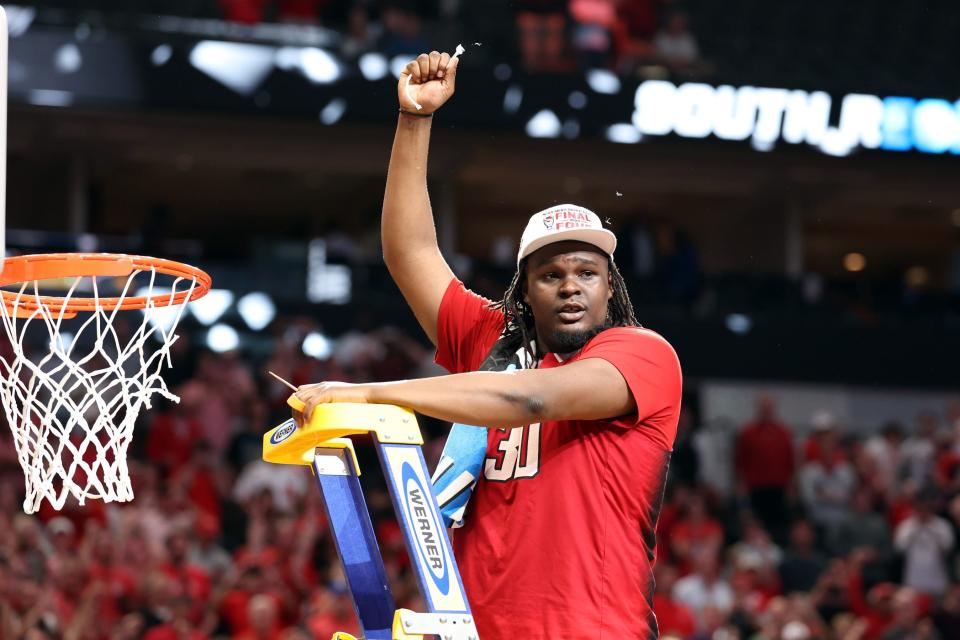 Mar 31, 2024; Dallas, TX, USA; North Carolina State Wolfpack forward DJ Burns Jr. (30) cuts the net after defeating the Duke Blue Devils in the finals of the South Regional of the 2024 NCAA Tournament at American Airline Center. Mandatory Credit: Kevin Jairaj-USA TODAY Sports
