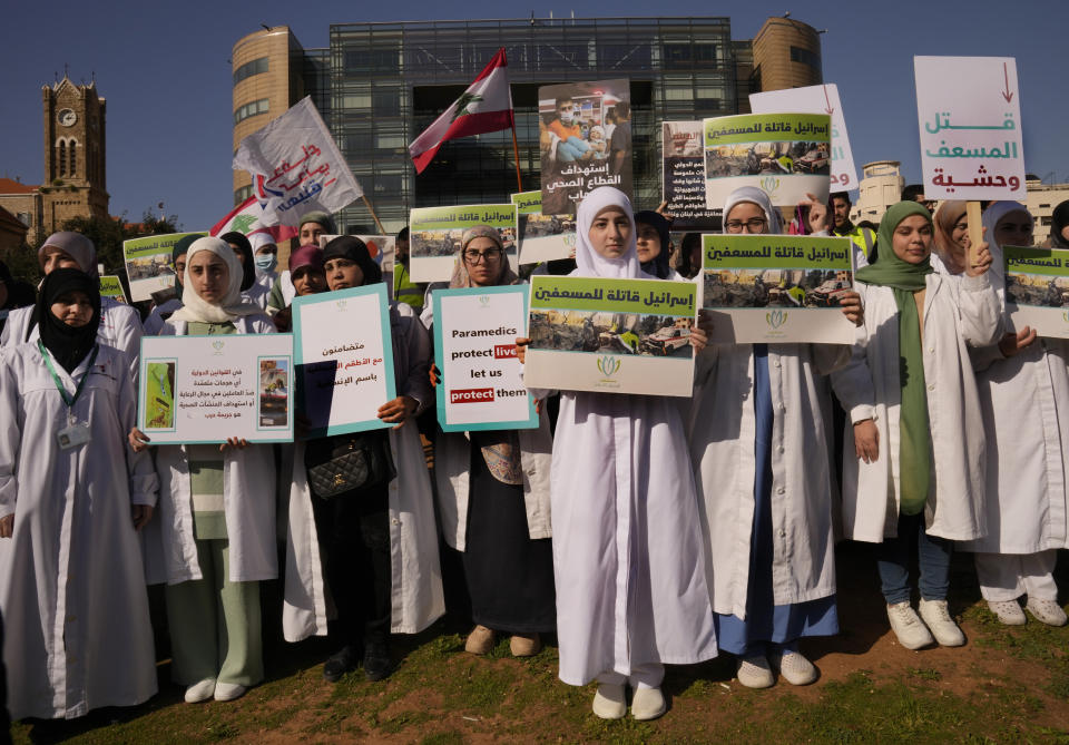 Lebanese paramedics hold placards as they attend a protest in supporting their colleagues in Gaza and Lebanon who were attacked by Israeli forces, in front of the headquarters of U.N. Economic and Social Commission for Western Asia (ESCWA) in Beirut, Lebanon, Tuesday, March 12, 2024. The Arabic placards read:"Israel is the killer of the paramedics, the killing of a paramedic is savagery."(AP Photo/Hussein Malla)