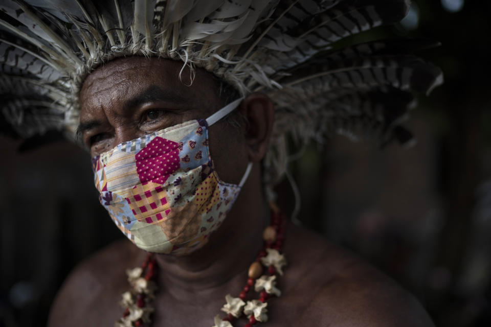 In this May 10, 2020 photo, Pedro dos Santos, the leader of a community named Park of Indigenous Nations, poses for a photo, in Manaus, Brazil. Manaus' lack of the new coronavirus treatment prompted Pedro dos Santos to drink tea made of chicory root, garlic and lime to combat a high fever that lasted 10 days. (AP Photo/Felipe Dana)