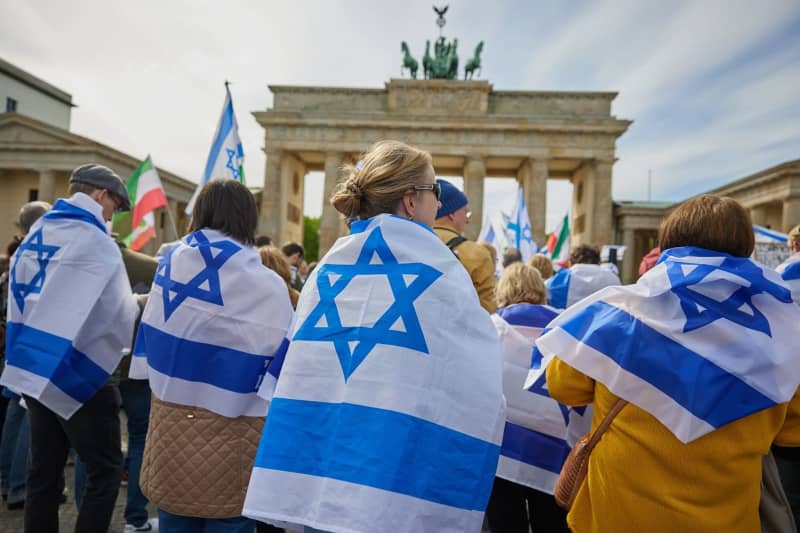 People take part in a solidarity demonstration by the German-Israeli Society (DIG) under the motto "Hands off Israel" on Pariser Platz. Jörg Carstensen/dpa