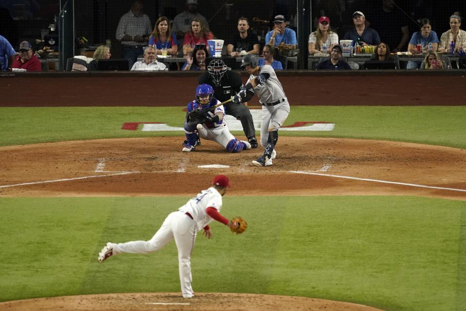 New York Yankees' Oswald Peraza, center right, hits into a double play on a pitch from Texas Rangers starting pitcher Martin Perez, front, as catcher Jonah Heim, center left, and umpire Andy Fletcher, rear, look on in the sixth inning of a baseball game in Arlington, Texas, Monday, Oct. 3, 2022. (AP Photo/Tony Gutierrez)