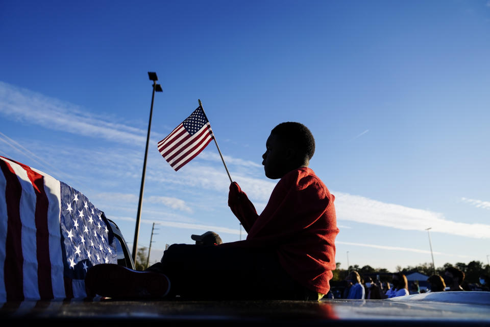 FILE - In this Nov. 15, 2020, file photo Xavier Watts, 9, waves an American flag during a camping rally for Georgia Democratic U.S. Senate candidates Jon Ossoff and Raphael Warnock in Marietta, Ga. (AP Photo/Brynn Anderson, File)