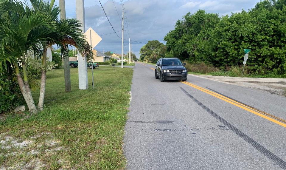 A vehicle moves to get out of the way of columnist Laurence Reisman walking on the edge of Second Street, west of Old Dixie Highway on Tuesday Sept. 19, 2023. The street is one of many in Indian River County, Florida, without a sidewalk, or in this case, even a bike lane.