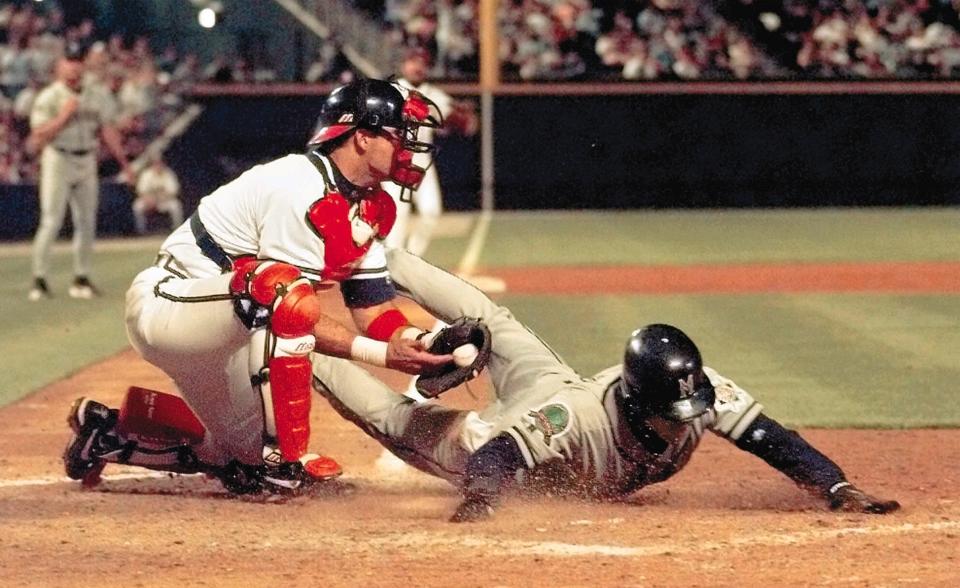 Milwaukee Brewers pinch runner Greg Martinez is tagged out by Atlanta Braves catcher Javy Lopez as he tries to score from second base on a base hit by Brewers' Fernando Vina during the ninth inning Thursday, April 2, 1998, in Atlanta.