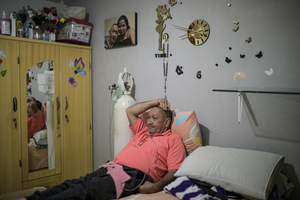 Victor Escobar lies at home during an interview in Cali, Colombia, Thursday, Jan. 6, 2022. Escobar, who suffers chronic obstructive pulmonary disease, oxygen dependence, lack of muscle control and secondary effects from a stroke is scheduled on the evening of Jan. 7 to become the first person to receive euthanasia legally, without being a terminally ill patient. Euthanasia for terminally ill patients is legal in Colombia. (AP Photo/Ivan Valencia)