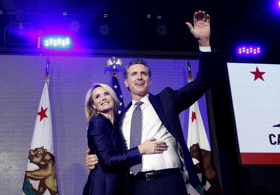 FILE -- In this Nov. 6, 2018 file photo Lt. Gov Gavin Newsom, a Democrat, hugs his wife,Jennifer Siebel Newsom as he celebrates at an election night party after he defeated Republican opponent John Cox to become 40th governor of California, in Los Angeles, Calif. Siebel Newsom has shunned the traditional title of "first lady" and is focusing on women's issues including equal pay and expanding family leave. (AP Photo/Rich Pedroncelli, File)