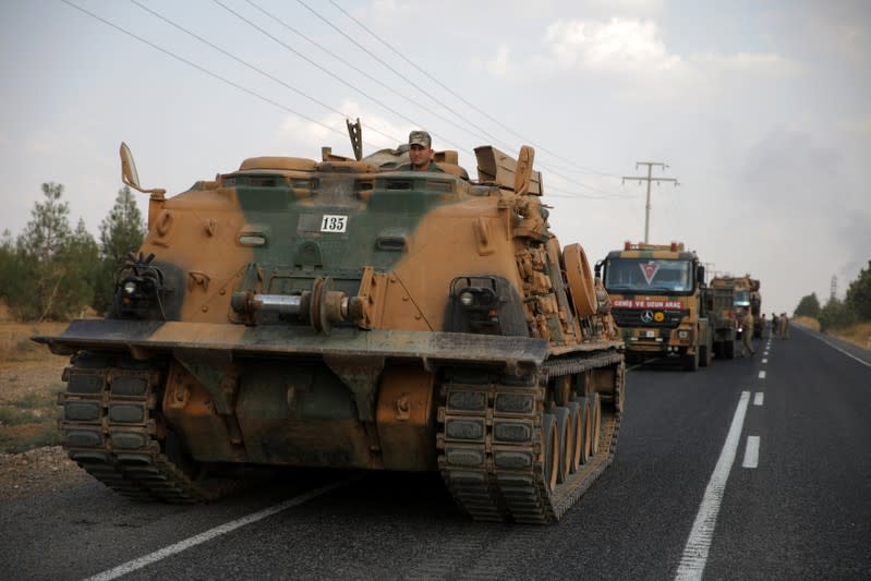 Turkish army vehicles are moving on a road near the Turkish border town of Ceylanpinar