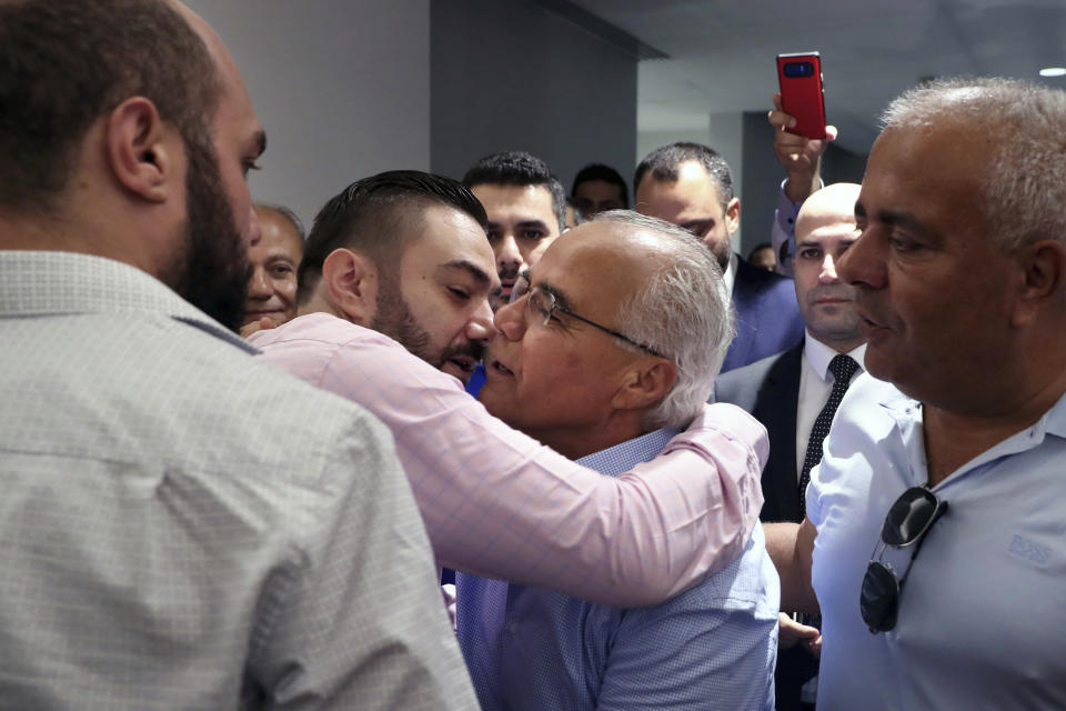 Mohammed Saleh, center, who was detained in Greece last week, is greeted by his son upon his arrival at the Rafik Hariri International Airport in Beirut, Lebanon, Wednesday, Sept. 25, 2019. Saleh, a Lebanese journalist who was mistakenly detained in Greece on suspicion of involvement in a 1985 TWA hijacking, arrived home in Lebanon. (AP Photo/Bilal Hussein)