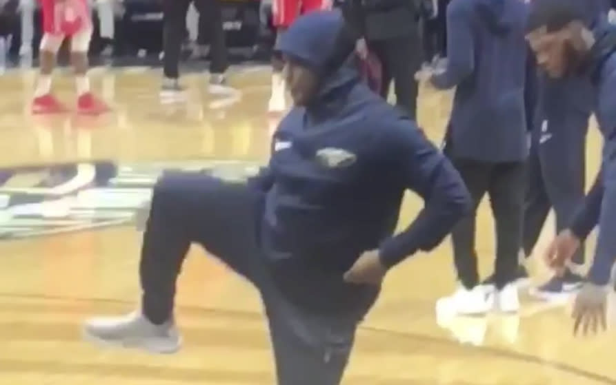 Pelicans fan Tony Roberts gets some light stretching in on the sidelines.