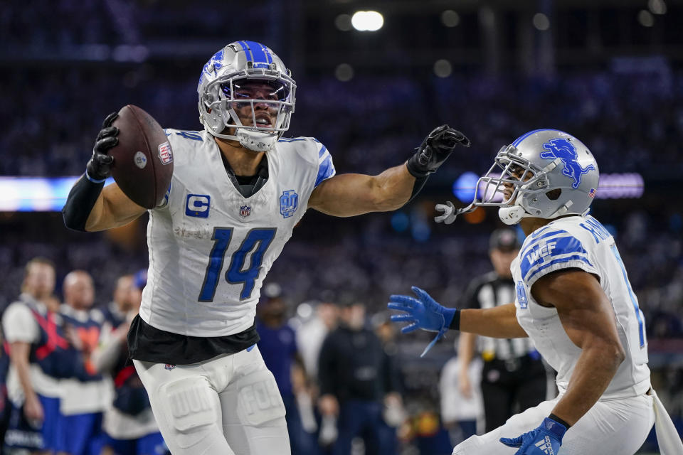 Detroit Lions wide receiver Amon-Ra St. Brown (14) celebrates his touchdown catch with wide receiver Kalif Raymond during the second half of an NFL football game against the Dallas Cowboys, Saturday, Dec. 30, 2023, in Arlington, Texas. The Cowboys won 20-19. (AP Photo/Sam Hodde)