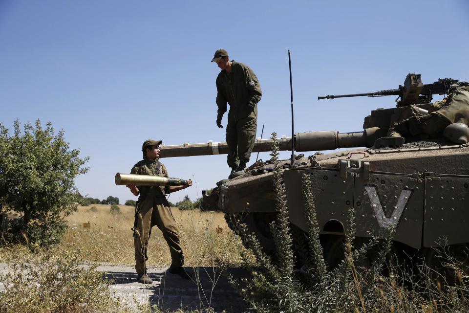 An Israeli soldier holds a tank shell near Alonei Habashan on the Israeli occupied Golan Heights, close to the ceasefire line between Israel and Syria June 22, 2014. REUTERS/Baz Ratner)
