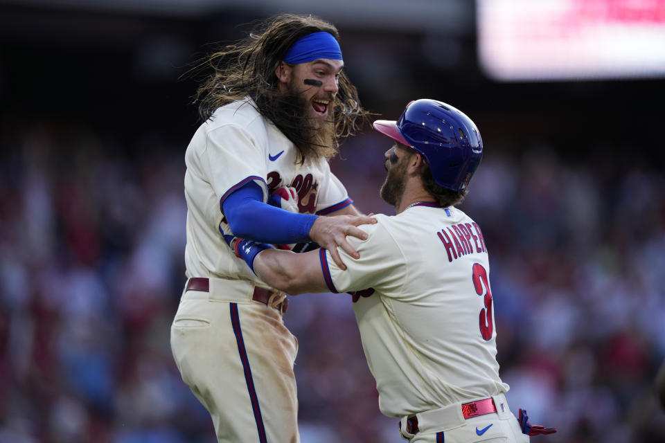 Philadelphia Phillies' Bryce Harper, right, and Brandon Marsh celebrate after Harper hit a game-winning fielder's choice during the 10th inning of a baseball game against the Toronto Blue Jays, Wednesday, May 10, 2023, in Philadelphia. (AP Photo/Matt Slocum)