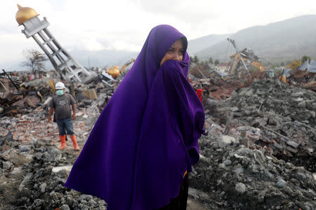 A woman missing her family walks in the destroyed by earthquake, Balaroa neighbourhood in Palu, Central Sulawesi, Indonesia October 6, 2018. REUTERS/Darren Whiteside