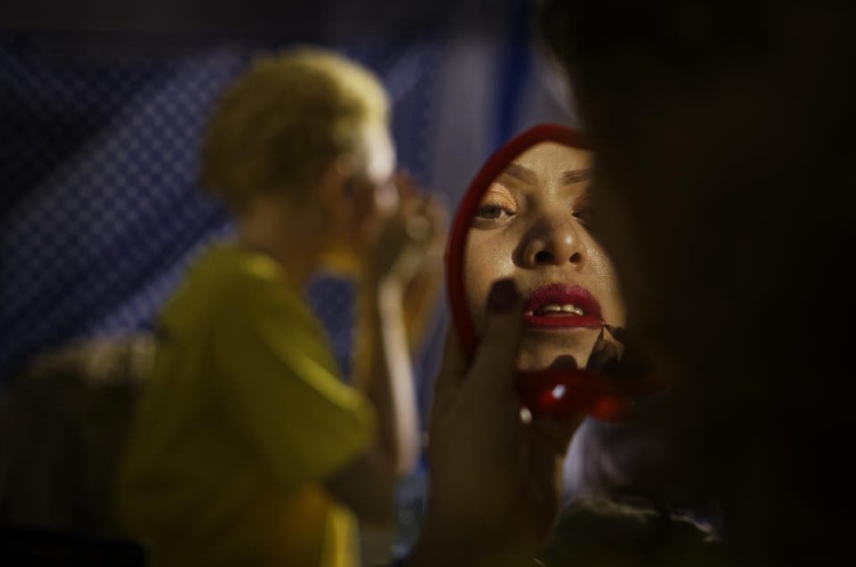 FILE - In this Friday, Nov. 30, 2018 file photo a contestant checks her makeup in a mirror as she prepares to perform in the "Mr. & Miss Albinism East Africa" contest, organized by the Albinism Society of Kenya, in Nairobi, Kenya. The event aims to promote social inclusion and raise the self-esteem of albinos, who frequently face discrimination and stigma. (AP Photo/Ben Curtis, File)