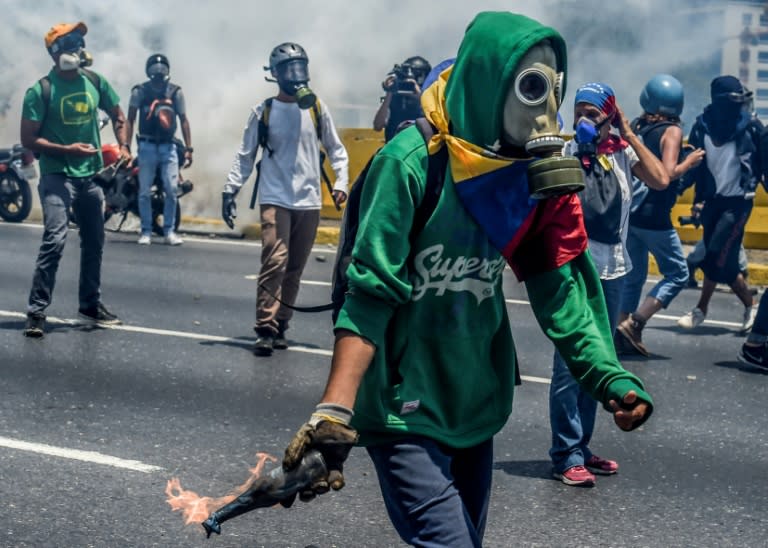 Venezuelan opposition activists clash with riot police during a protest march against President Nicolas Maduro in Caracas on April 26, 2017