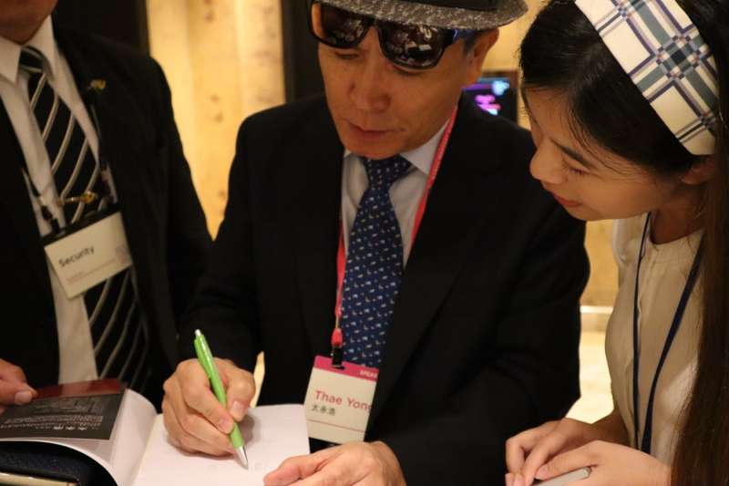 史上官階最高的脫北者、前北韓駐英公使太永浩9月13日出席台北「奧斯陸自由論壇」，親切替書迷簽名。（王穎芝攝）