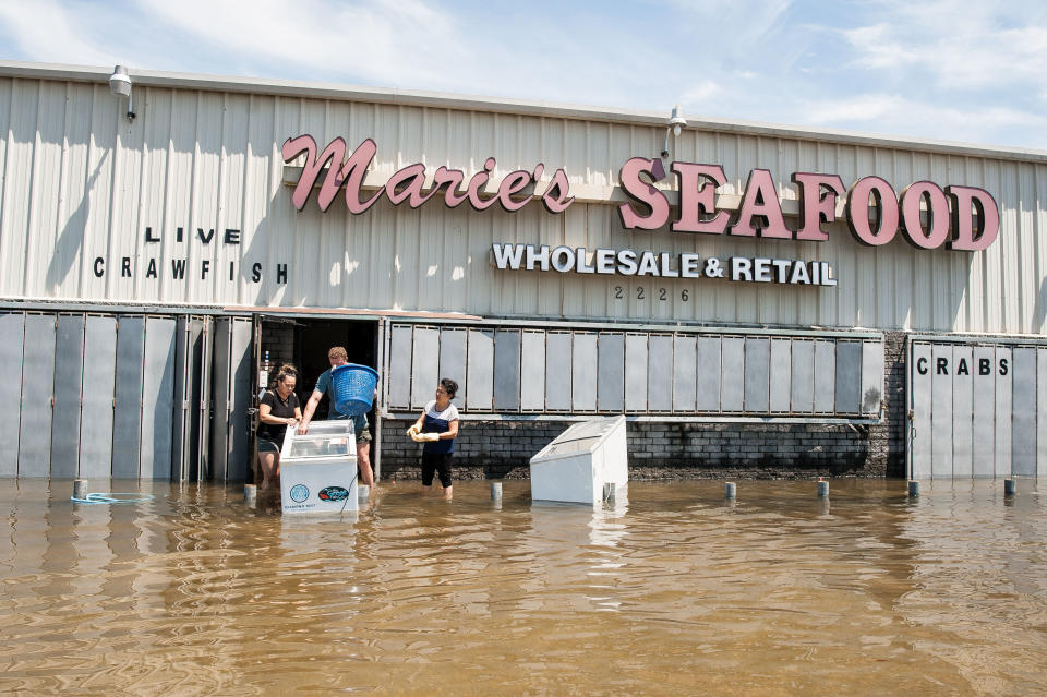 Hanh Nguyen, owner of Marie's Seafood Market, attempts to salvage goods from her store with the help of her family.