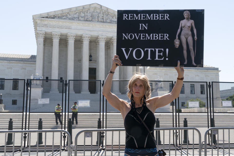 Nicky Sundt, of Washington, holds a sign with an image depicting Medusa that says, "Remember in November, Vote!," outside of the Supreme Court, Wednesday, June 29, 2022, in Washington. "I'm trans and I identify as female," says Sundt, "all the women in my life have supported me in my transition, and the least I can do is to come here and support them. I don't have voting rights living in DC so what is there left to do but hold signs and protest." She is concerned about climate change, women's rights, and gay rights. (AP Photo/Jacquelyn Martin)