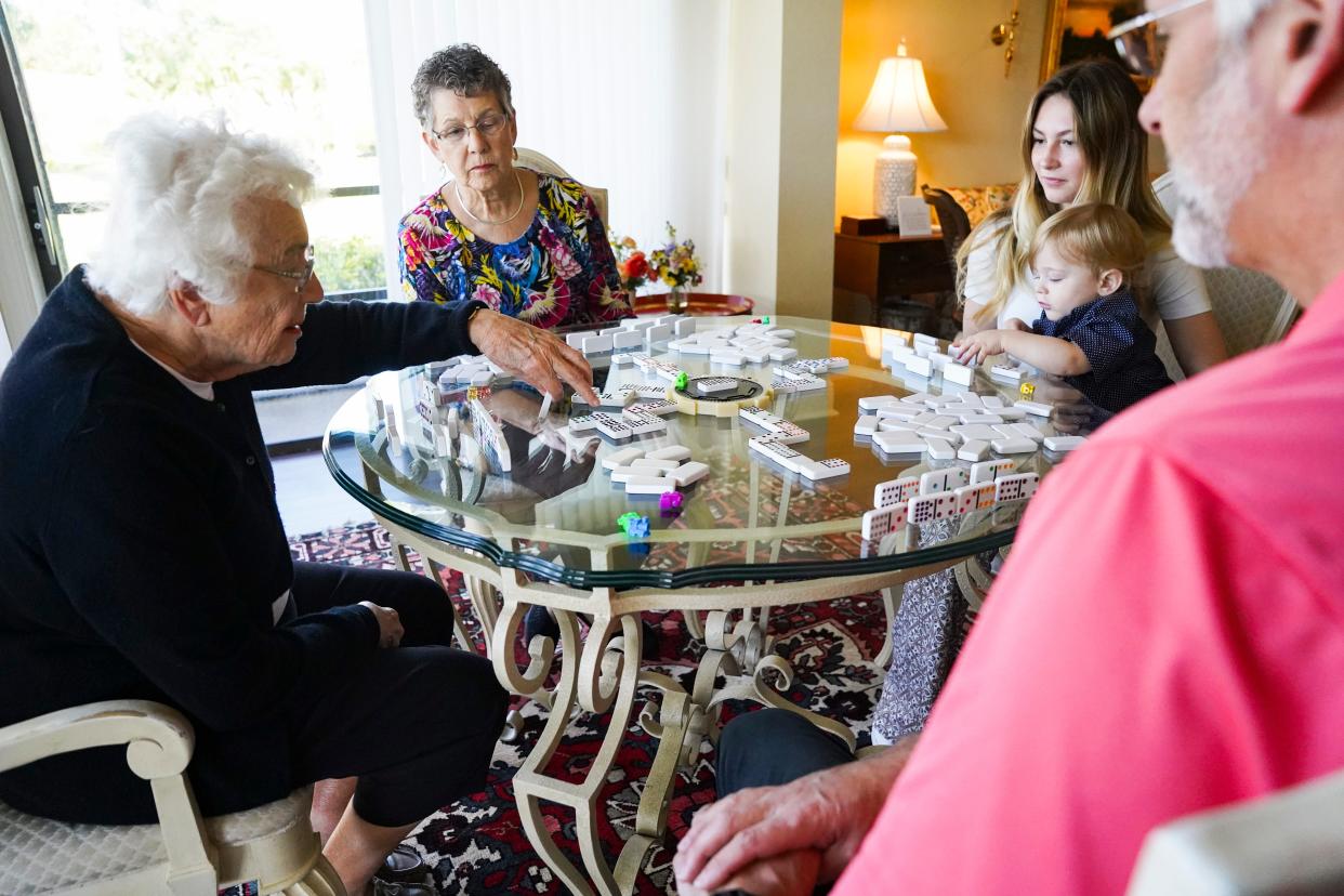 Lydia Kruesi, 100, left, plays dominos with her daughter Cindy, 76, center left, grandson Scott Duval, 50, great-granddaughter Brooke Duval, 19, and great-great-grandson Greyson, 1, at Vi at Bentley Village retirement community in Naples on Monday, May 1, 2023.
