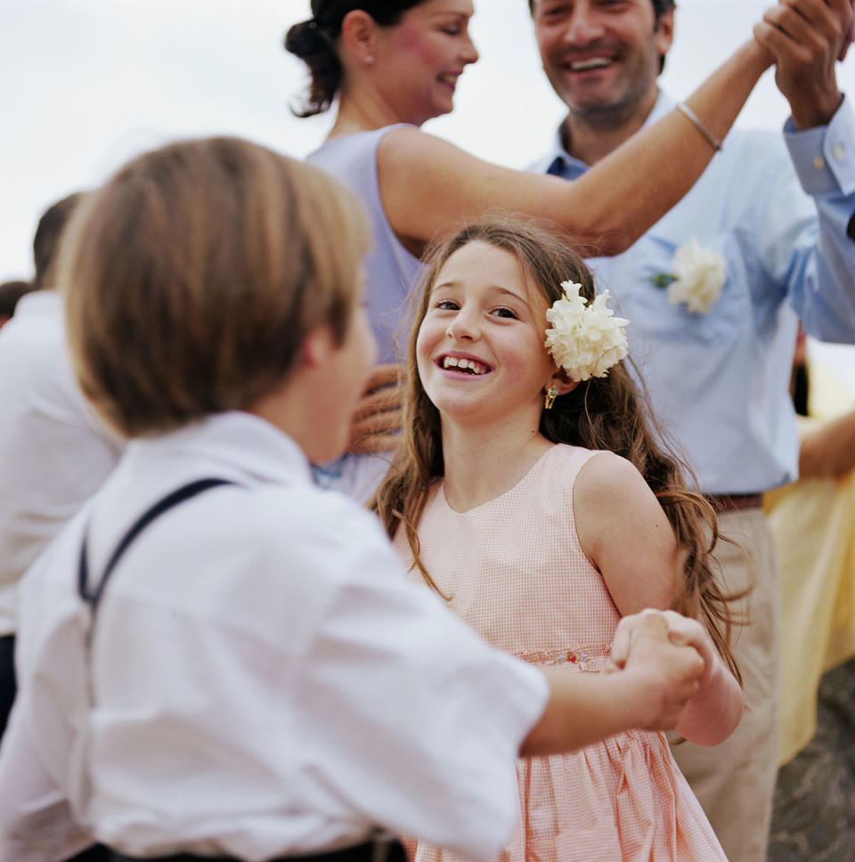 A young boy and girl dance at a wedding