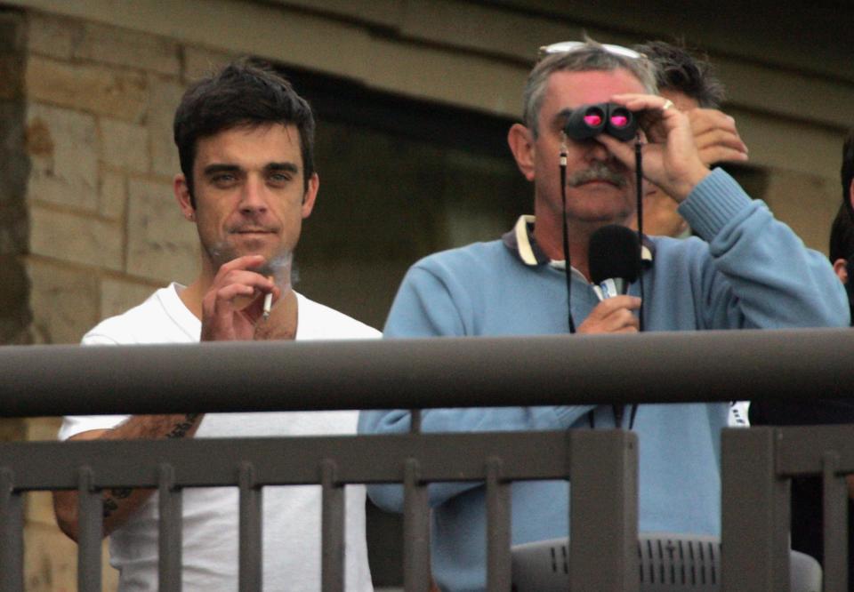 NEWPORT, WALES - AUGUST 29: Robbie Williams (L) watches the match on the final day of The All-Star Cup Celebrity Golf tournament at the Celtic Manor Resort on August 29, 2005 Newport, Wales. The cup, brainchild of Anthony McPartlin and Declan Donnelly, sees 2 teams of 10 celebrities from Europe and the US taking part over the Roman Road course, venue of the 2010 Ryder Cup, with Colin Montgomerie and Mark O?Meara as the non-playing captains of the European and US teams respectively.  The cup will be presented by Kirsty Gallacher and Jamie Theakston. (Photo by Matt Cardy/Getty Images)