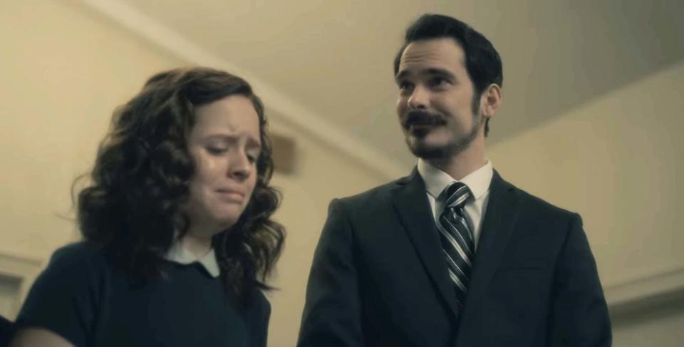 closeup of two people at a funeral, one crying