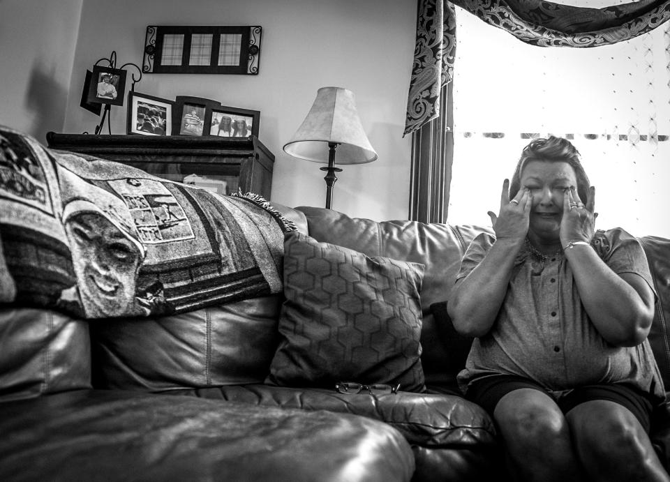 Beth Genslinger tells the story of her son, Andy, who died from a heroin overdose in his bedroom in Germantown, Ohio. He is pictured on a blanket next to her. (Photograph by Mary F. Calvert for Yahoo News)