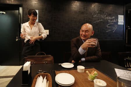 Shiro Fukai, 48, drinks distilled spirit next to manager Yoshiko Toyoda (L) at the Otasuke "izakaya" style pub and restaurant in Tokyo May 8, 2014. REUTERS/Toru Hanai