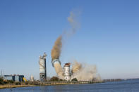 The smokestack at the former B.L. England Generating Station, a coal and oil burning power plant in Upper Township, N.J., is toppled during a control demolition on Thursday, October 26, 2023. The site will be redeveloped as a mixed-use residential and commercial project, and a nearby electrical substation will be used to connect New Jersey's soon-to-come offshore wind farms with the electrical grid. (AP Photo/Ted Shaffrey)