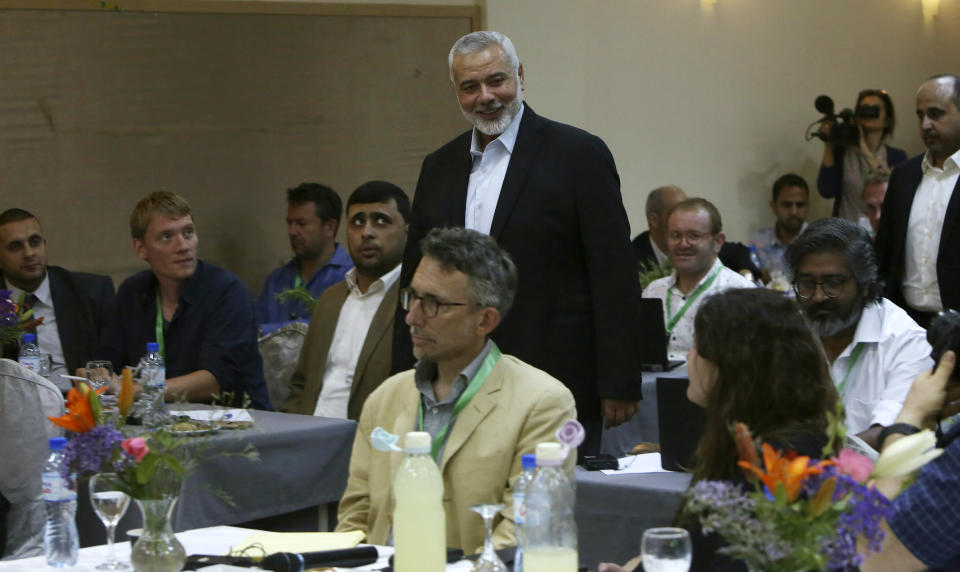 Hamas' chief Ismail Haniyeh, center, arrives to a meeting with foreign reporters at al-Mat'haf hotel in Gaza City, Thursday, June 20, 2019. Hamas' chief says Israel is ignoring the terms of an indirect cease-fire agreement for the Gaza Strip. (AP Photo/Adel Hana)