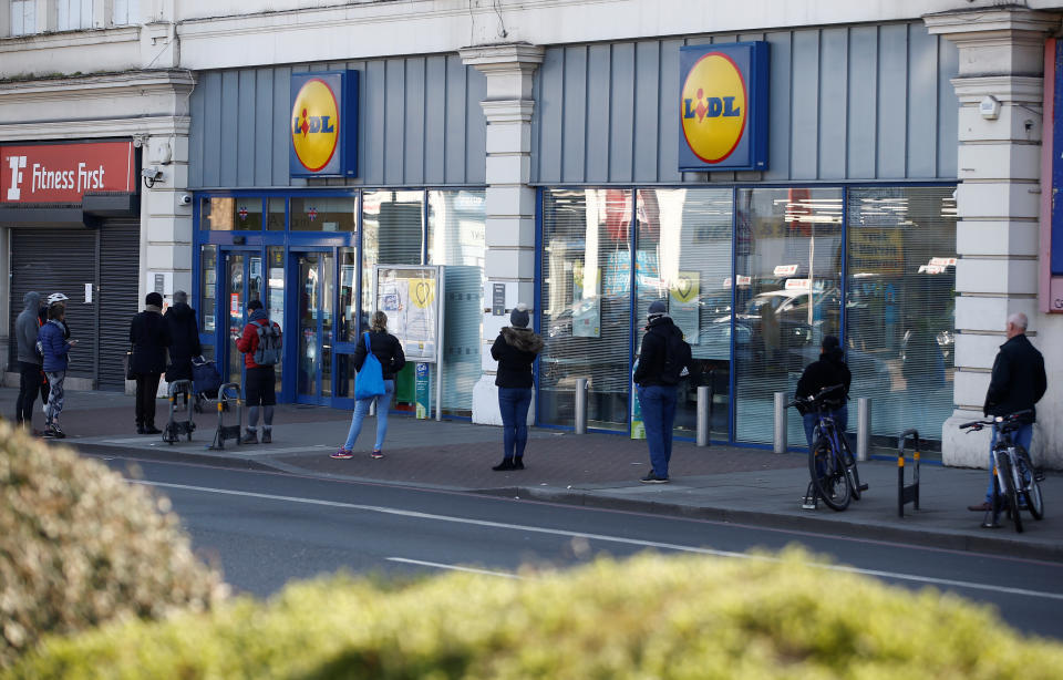 People follow social distancing rules while they queue outside a Lidl store in South London as the spread of the coronavirus disease (COVID-19) continues, in London, Britain, March 27, 2020. REUTERS/Henry Nicholls