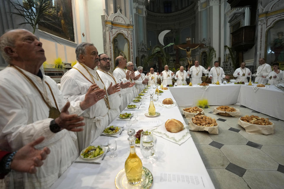 Members of a confraternity re-enact the Last Supper, bless loaves of bread in the Sant'Antonio Abate church during a Holy Thursday procession the in Procida Island, Italy, Thursday, March 28, 2024. Italy is known for the religious processions that take over towns big and small when Catholic feast days are celebrated throughout the year. But even in a country where public displays of popular piety are a centuries-old tradition, Procida's Holy Week commemorations stand out. (AP Photo/Alessandra Tarantino)