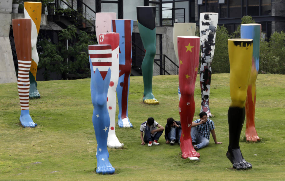 In this May 7, 2013 photo, visitors rest near the artistic objects at the Hongfang Creative Industrial Zone in Shanghai, China. The Hongfang Creative Industrial Zone, created in 2005 out of a cluster of renovated factories, houses galleries including the Shanghai Sculpture Space, open Tuesday-Sunday, which shows work by Chinese and foreign contemporary artists. (AP Photo/Eugene Hoshiko)