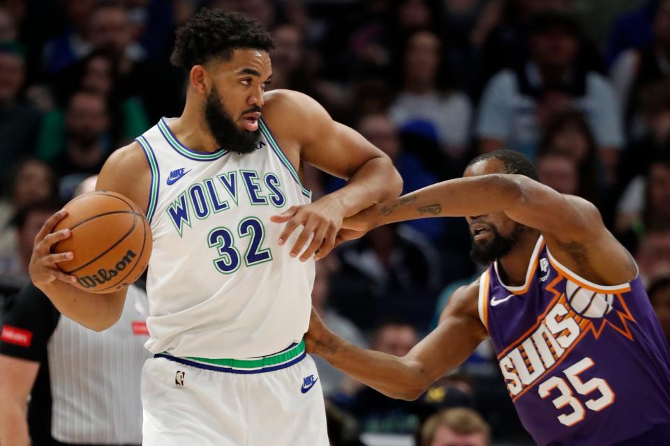 Minnesota Timberwolves forward Karl-Anthony Towns (32) works against the defense of Phoenix Suns forward Kevin Durant (35) in the first quarter at Target Center in Minneapolis on April 14, 2024.