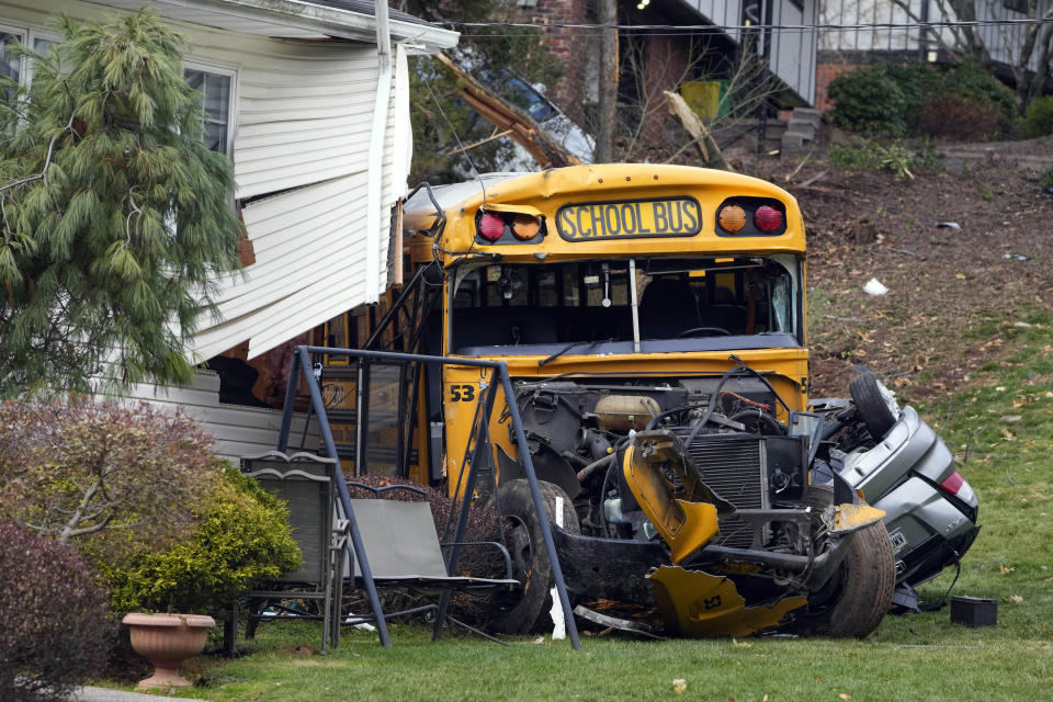 A school bus involved in an accident is seen in New Hempstead, N.Y., Thursday, Dec. 1, 2022. Multiple injuries were reported Thursday when a school bus crashed into a house and another vehicle in a suburb north of New York City. (AP Photo/Seth Wenig)
