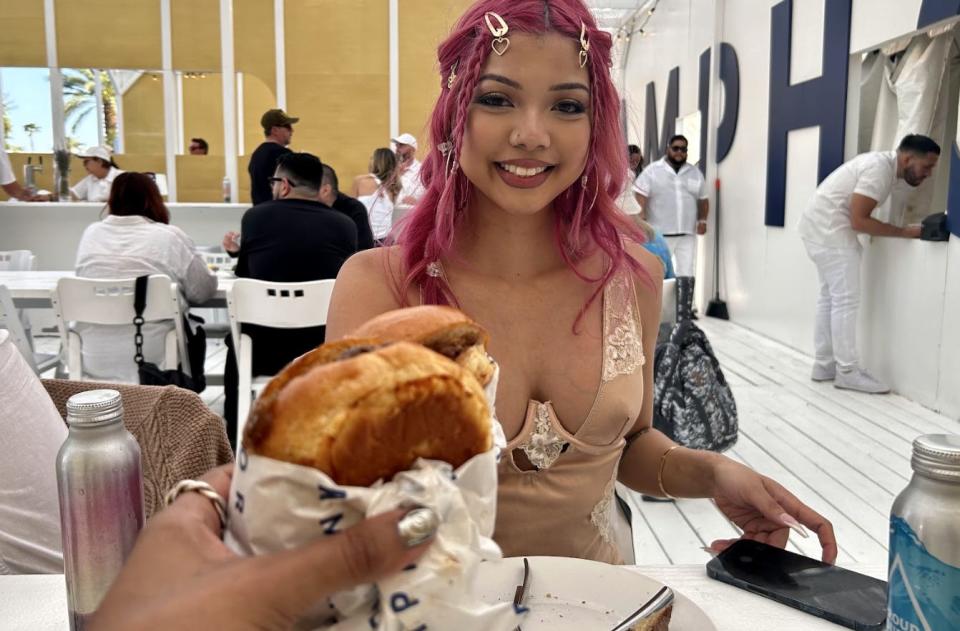 woman with pink hair holding burger in Camphor pop up