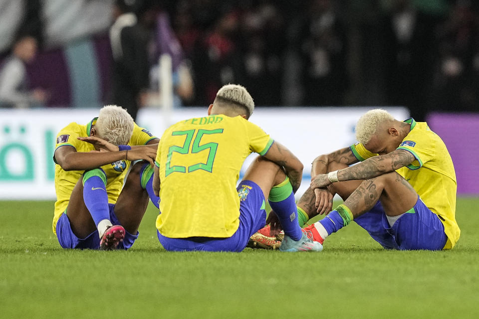 Brazil's Rodrygo, Brazil's Pedro and Brazil's Neymar, from right, sit on the pitch after losing the World Cup quarterfinal soccer match between Croatia and Brazil, at the Education City Stadium in Al Rayyan, Qatar, Friday, Dec. 9, 2022. (AP Photo/Martin Meissner)