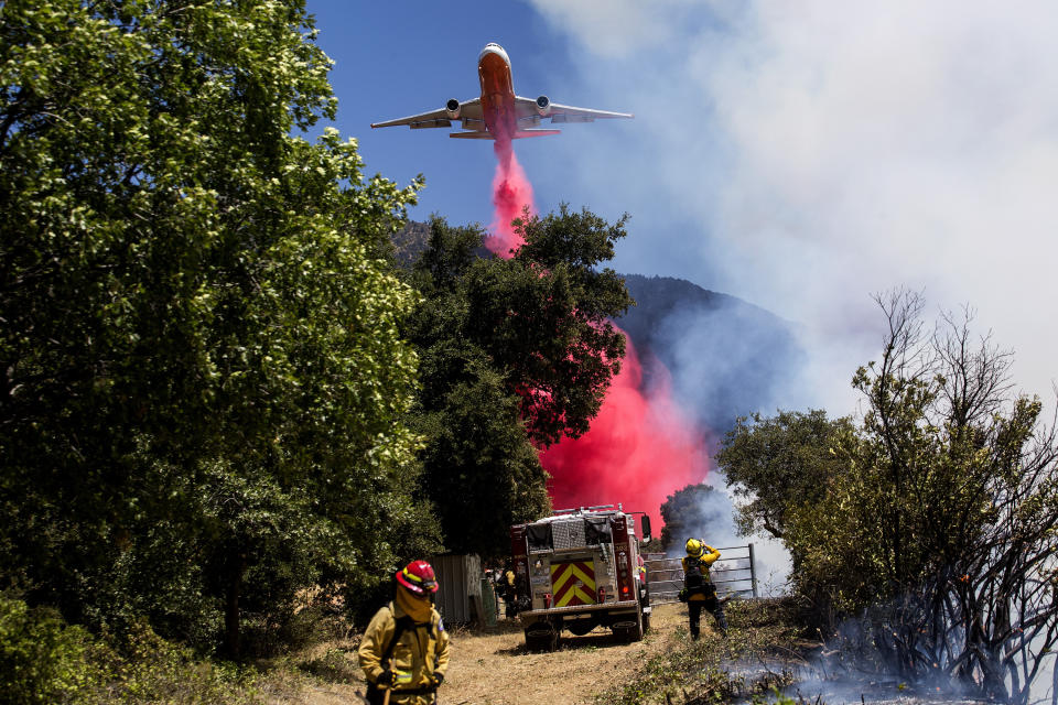 An air tanker drops fire retardant at the Apple Fire in Cherry Valley, Calif., Saturday, Aug. 1, 2020. A wildfire northwest of Palm Springs flared up Saturday afternoon, prompting authorities to issue new evacuation orders as firefighters fought the blaze in triple-degree heat.(AP Photo/Ringo H.W. Chiu)